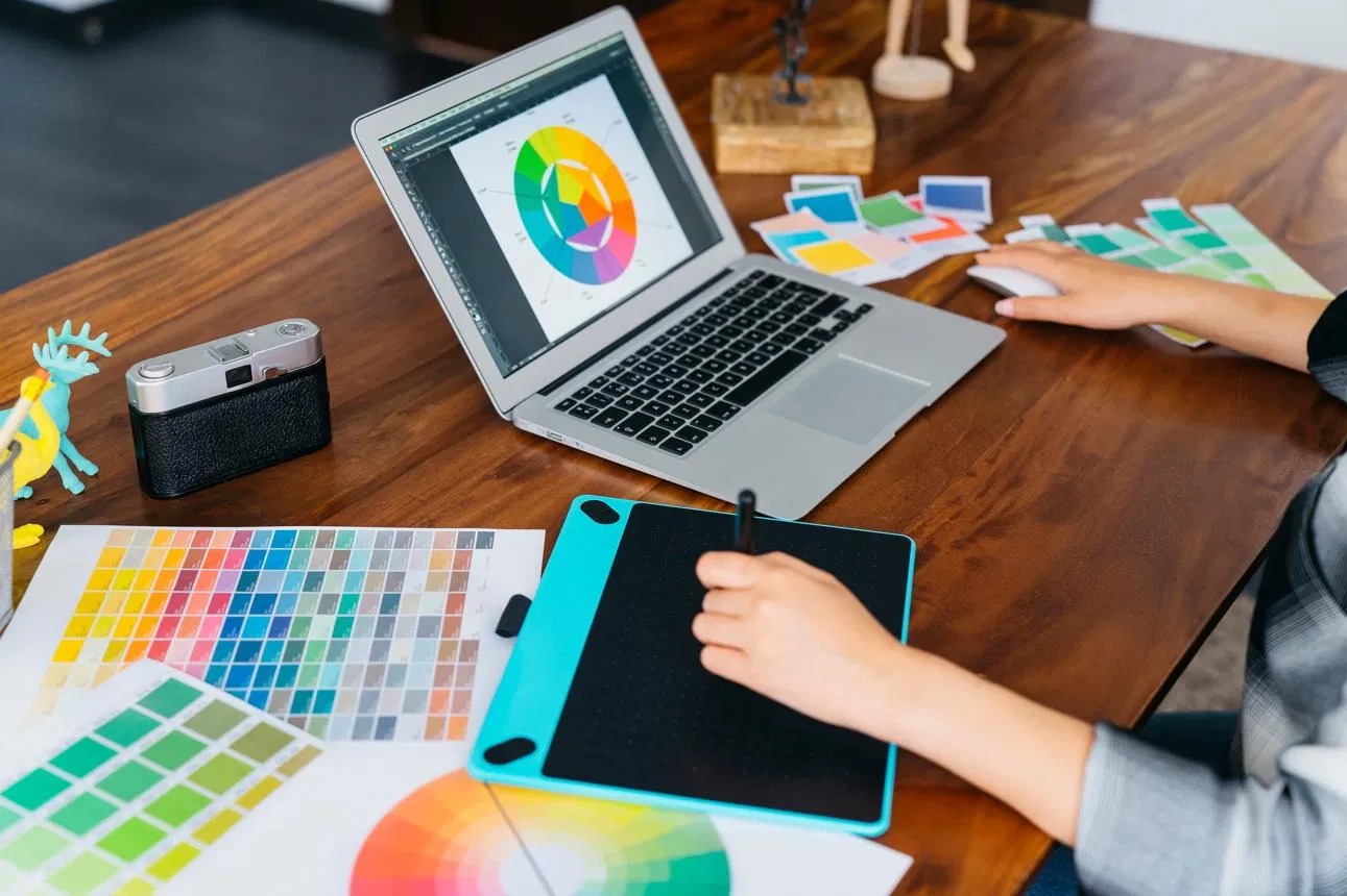 Graphic designer working with color palettes and a drawing tablet